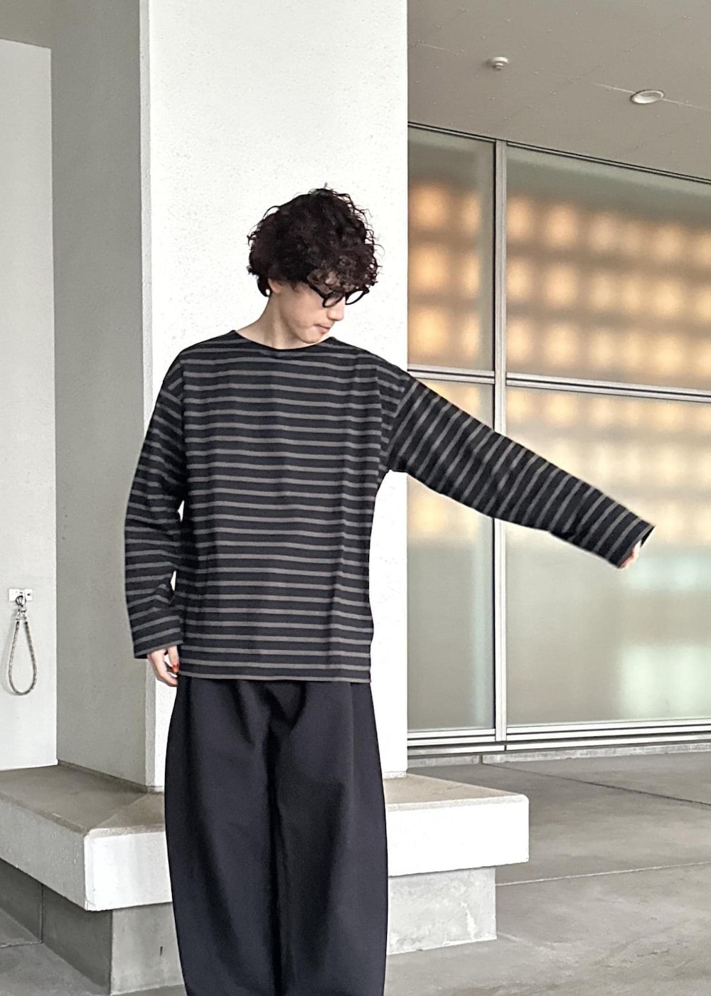 ブラック系のスラックス、ブラウン系のTシャツ/カットソー、ブルー系のセットアップを着用したメンズの春コーディネートの8枚目の写真