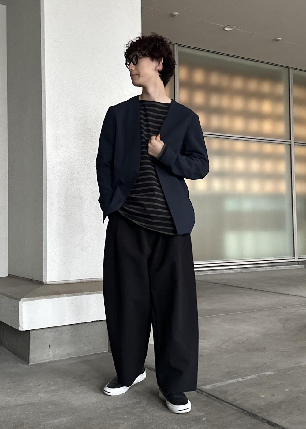 ブラック系のスラックス、ブラウン系のTシャツ/カットソー、ブルー系のセットアップを着用したメンズの春コーディネートの5枚目の写真