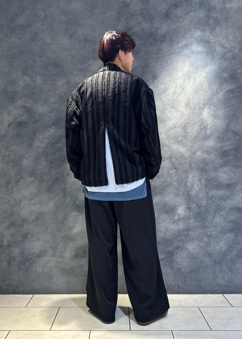 ブルー系のネクタイ、ブラック系のテーラードジャケット、ブルー系のTシャツ/カットソーを着用したメンズの冬コーディネートの3枚目の写真