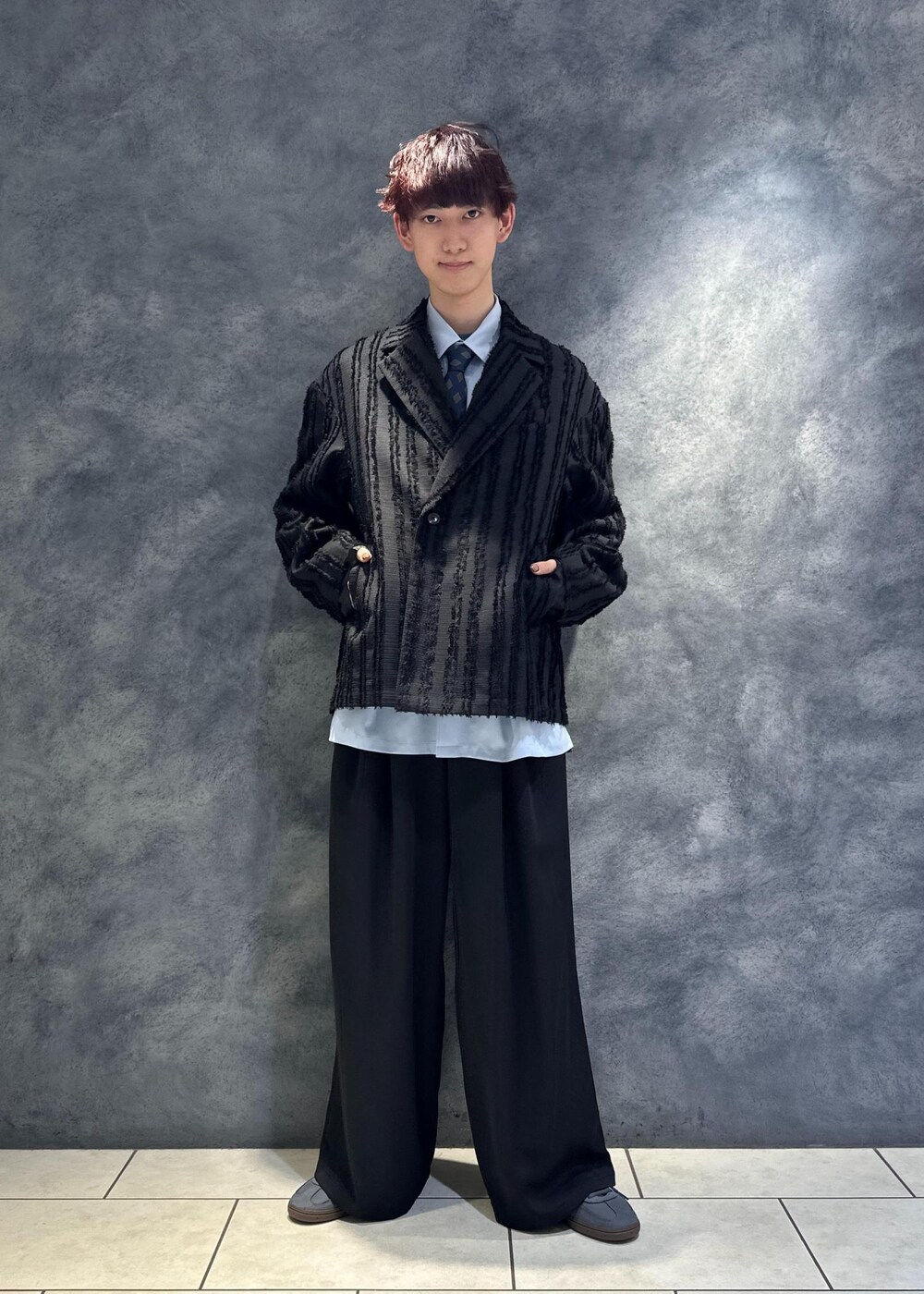 ブルー系のネクタイ、ブラック系のテーラードジャケット、ブルー系のTシャツ/カットソーを着用したメンズの冬コーディネートの6枚目の写真