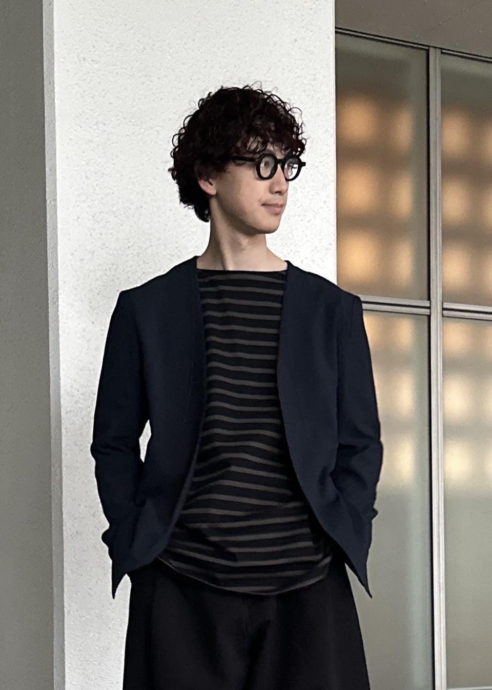 ブラック系のスラックス、ブラウン系のTシャツ/カットソー、ブルー系のセットアップを着用したメンズの春コーディネートの6枚目の写真