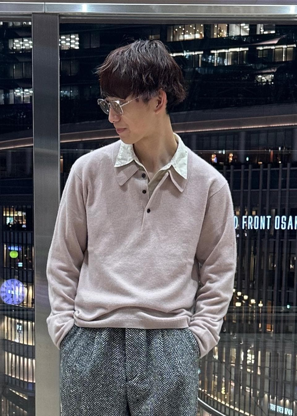 ブラック系のその他パンツ、ブラック系のステンカラーコート、ピンク系のポロシャツを着用したメンズの冬コーディネートの9枚目の写真