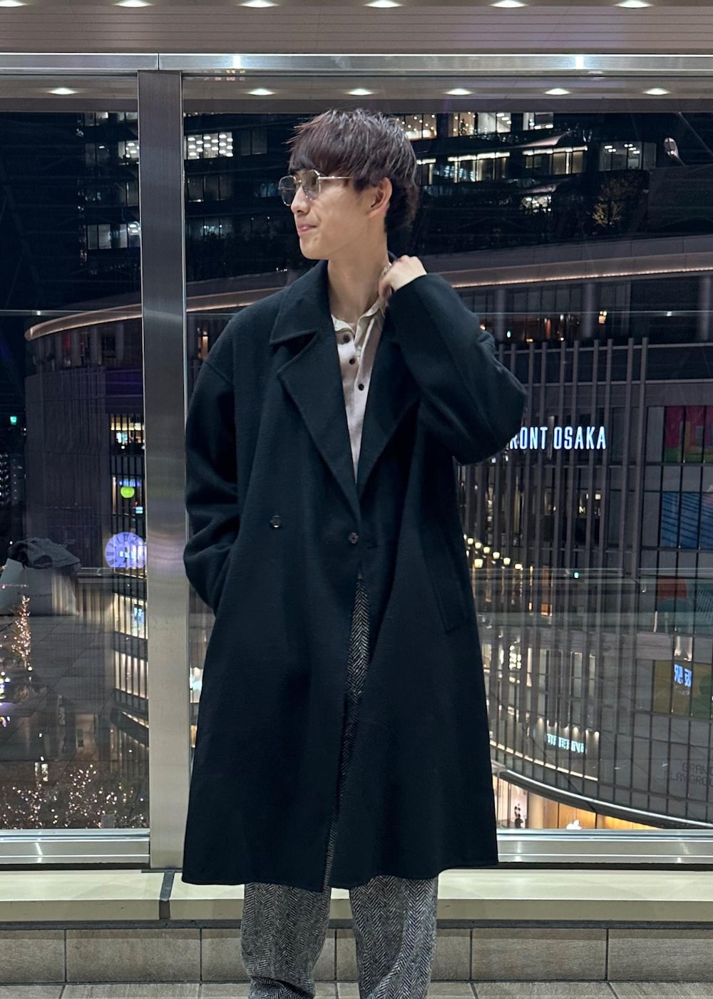 ブラック系のその他パンツ、ブラック系のステンカラーコート、ピンク系のポロシャツを着用したメンズの冬コーディネートの3枚目の写真