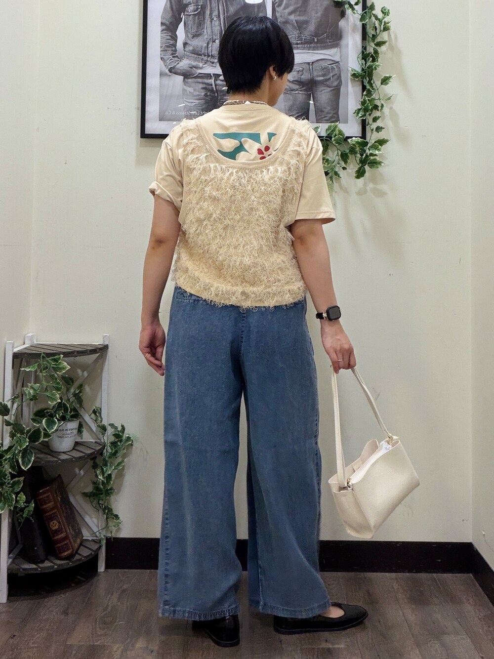 ベージュ系のTシャツ/カットソー、ホワイト系のベスト、ブルー系のデニムパンツを着用したレディースの春コーディネートの3枚目の写真