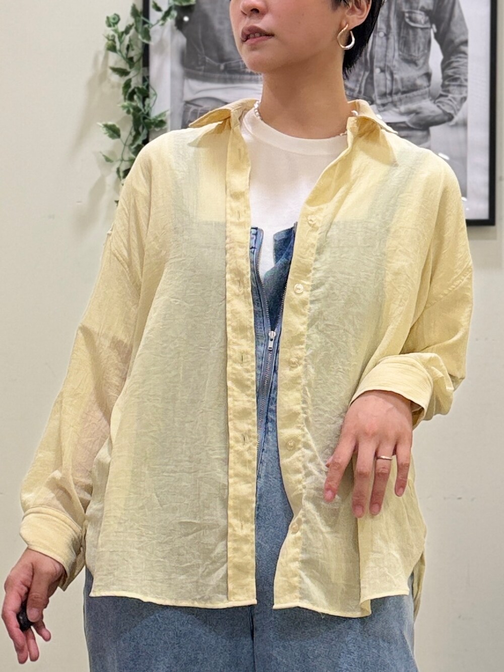 ブルー系のサロペット/オーバーオール、イエロー系のシャツ/ブラウス、ベージュ系のショルダーバッグを着用したレディースの春コーディネートの4枚目の写真