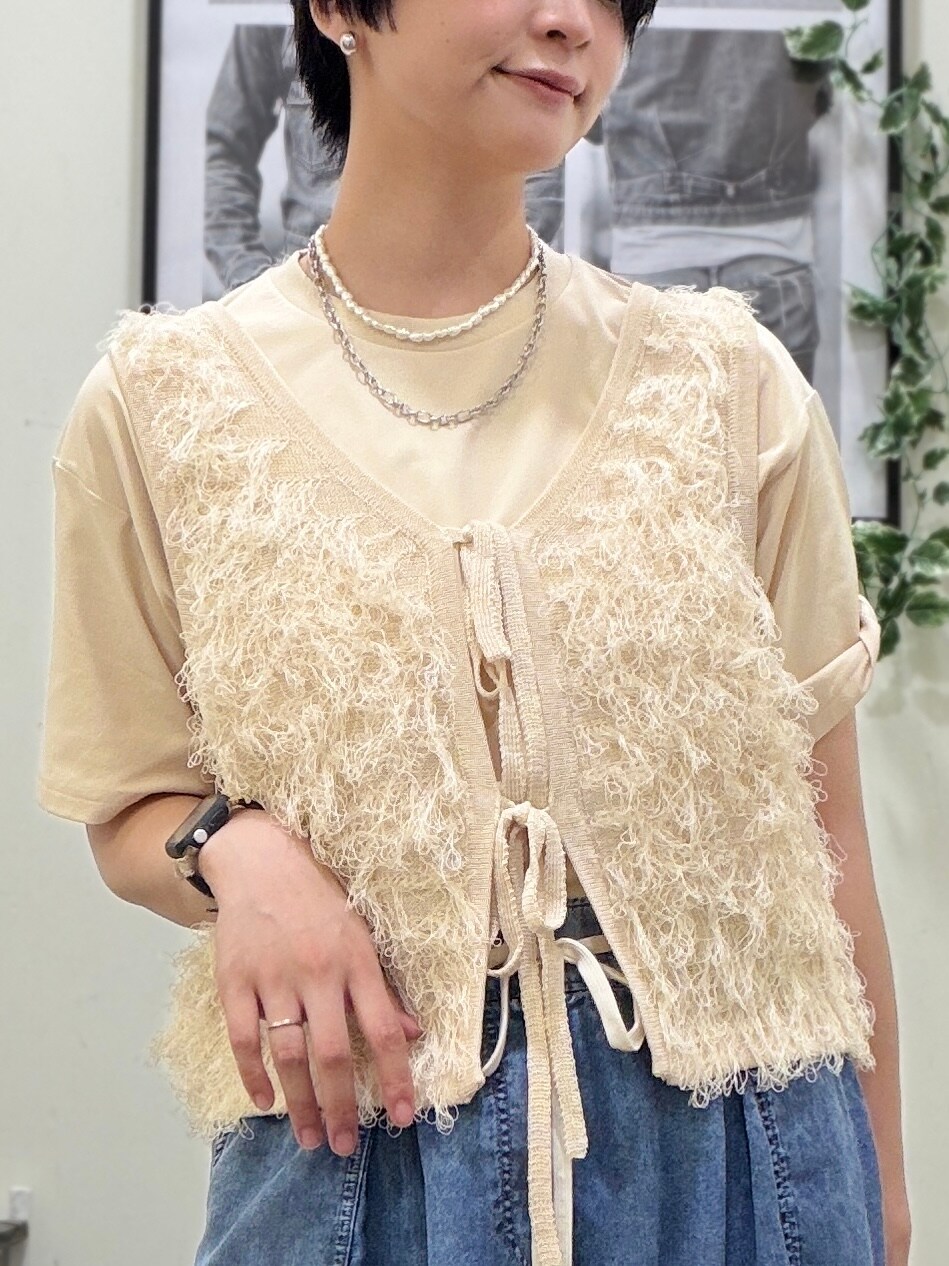 ベージュ系のTシャツ/カットソー、ホワイト系のベスト、ブルー系のデニムパンツを着用したレディースの春コーディネートの6枚目の写真
