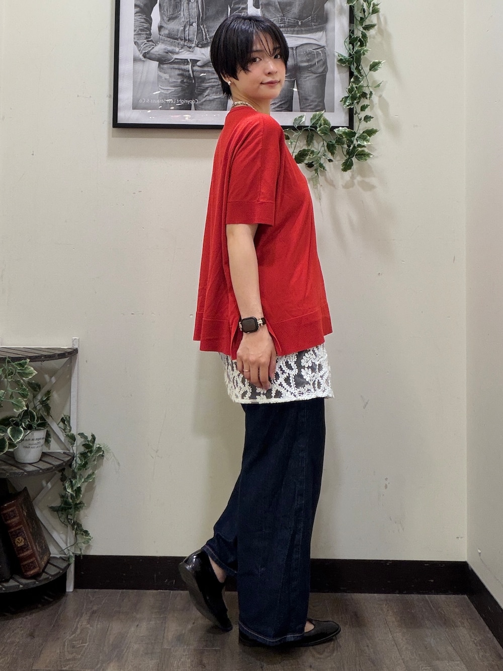 ブルー系のデニムパンツ、レッド系のニット/セーター、ホワイト系のスカートを着用したレディースの春コーディネートの2枚目の写真