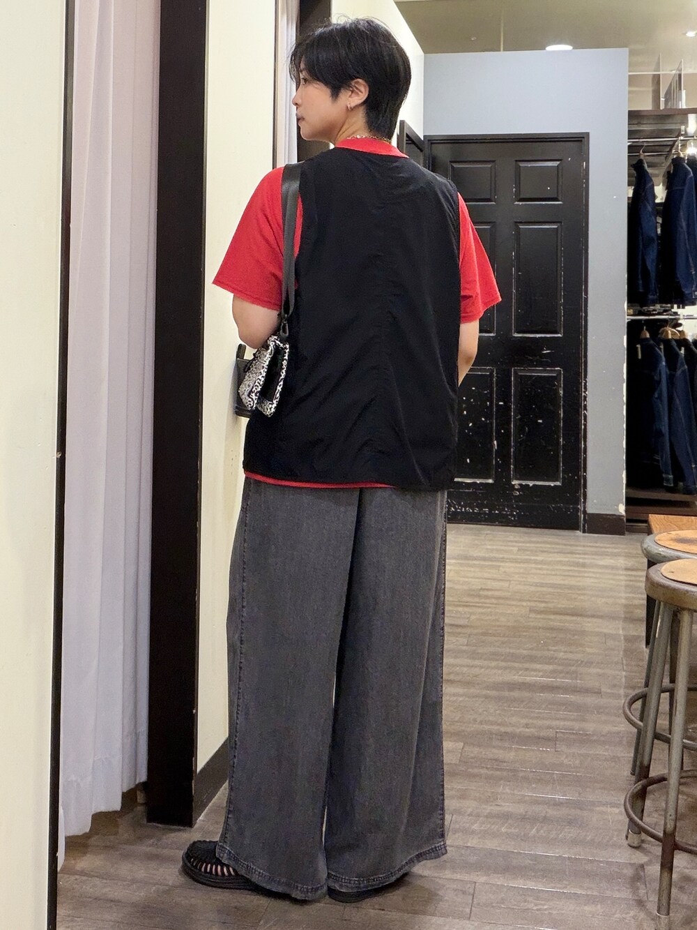 ブラック系のデニムパンツ、レッド系のTシャツ/カットソー、ブラック系のシャツ/ブラウスを着用したレディースの夏コーディネートの3枚目の写真