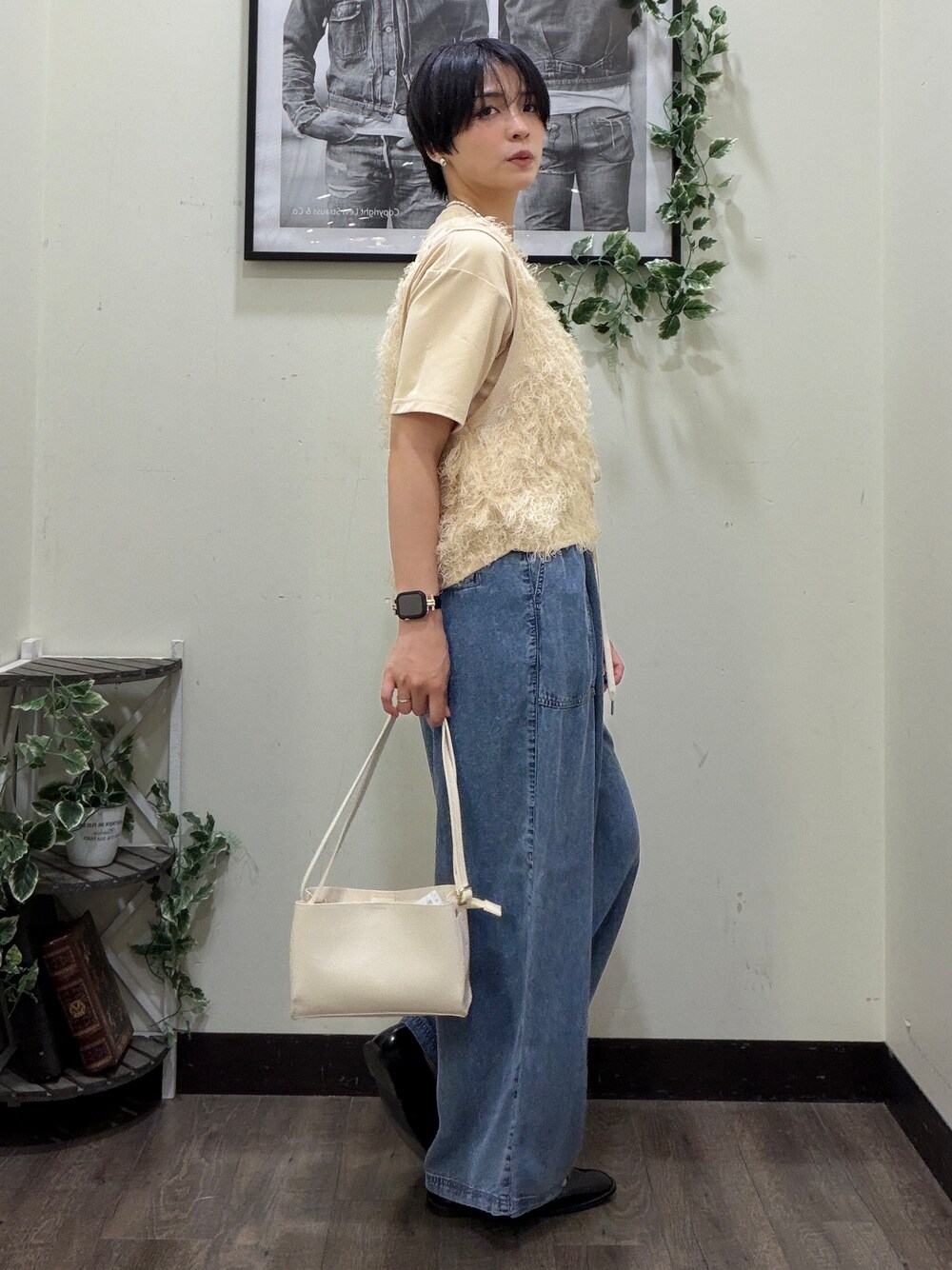 ベージュ系のTシャツ/カットソー、ホワイト系のベスト、ブルー系のデニムパンツを着用したレディースの春コーディネートの2枚目の写真