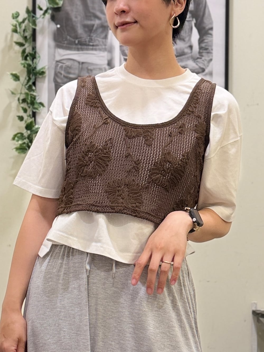 イエロー系のショルダーバッグ、グレー系のスカート、ブラウン系のベストを着用したレディースの春コーディネートの4枚目の写真