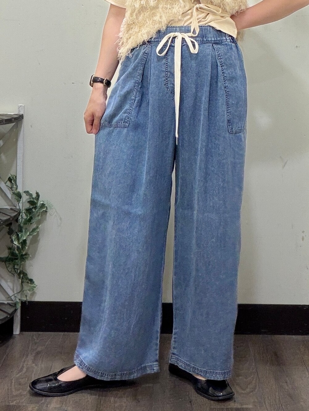 ベージュ系のTシャツ/カットソー、ホワイト系のベスト、ブルー系のデニムパンツを着用したレディースの春コーディネートの7枚目の写真
