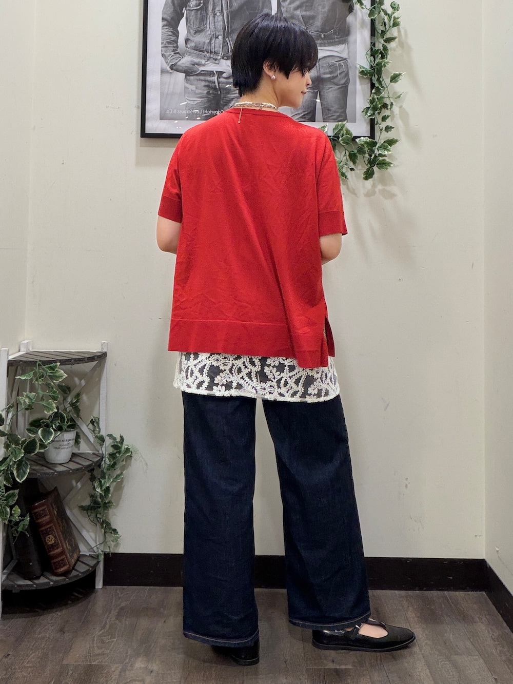 ブルー系のデニムパンツ、レッド系のニット/セーター、ホワイト系のスカートを着用したレディースの春コーディネートの3枚目の写真