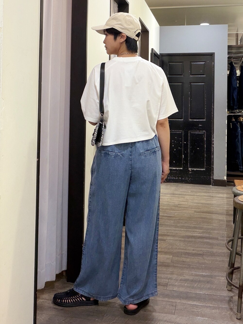 ホワイト系のTシャツ/カットソー、ブルー系のデニムパンツ、ホワイト系のボディバッグ/ウエストポーチを着用したレディースの夏コーディネートの2枚目の写真
