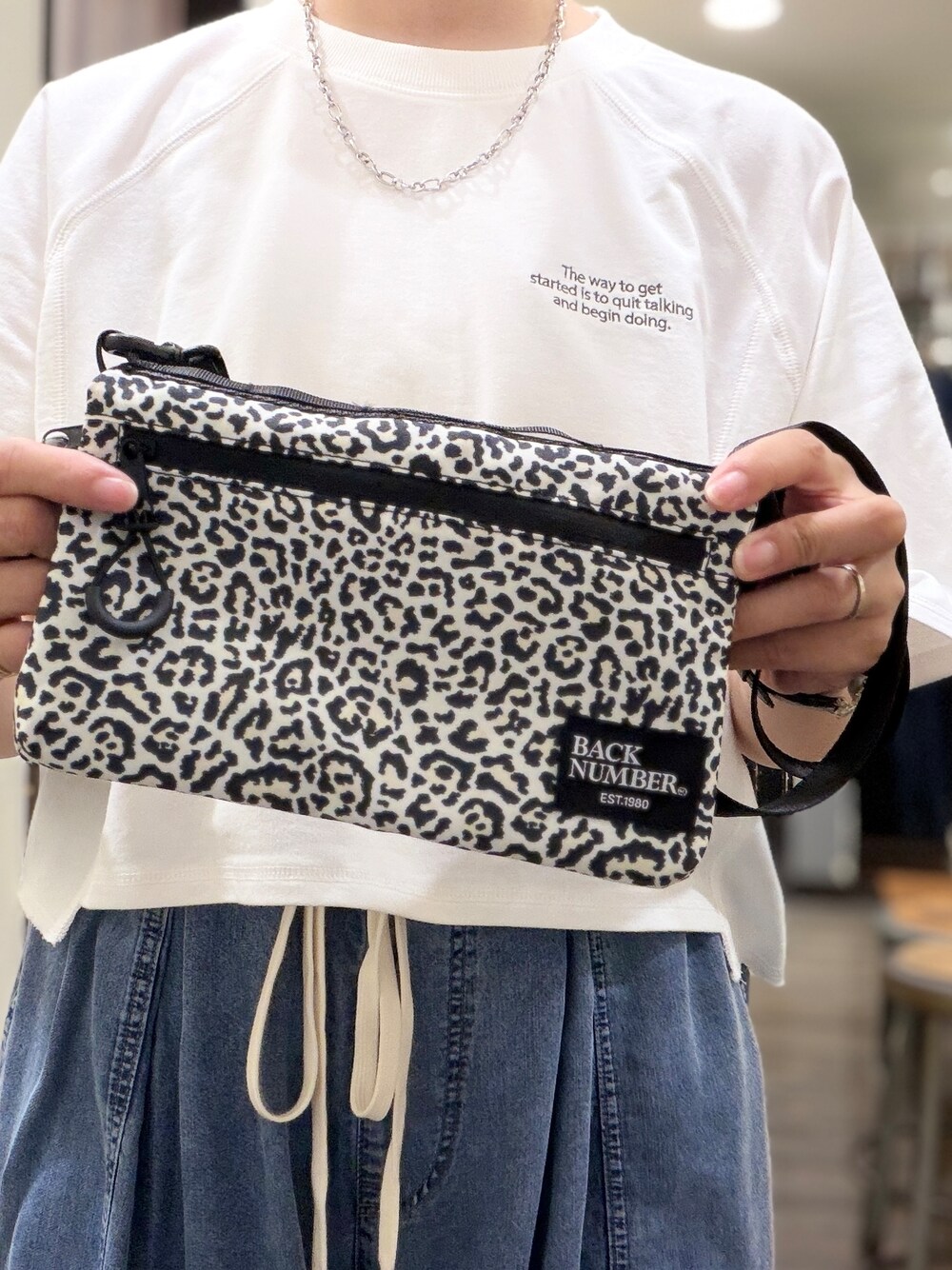 ホワイト系のTシャツ/カットソー、ブルー系のデニムパンツ、ホワイト系のボディバッグ/ウエストポーチを着用したレディースの夏コーディネートの7枚目の写真