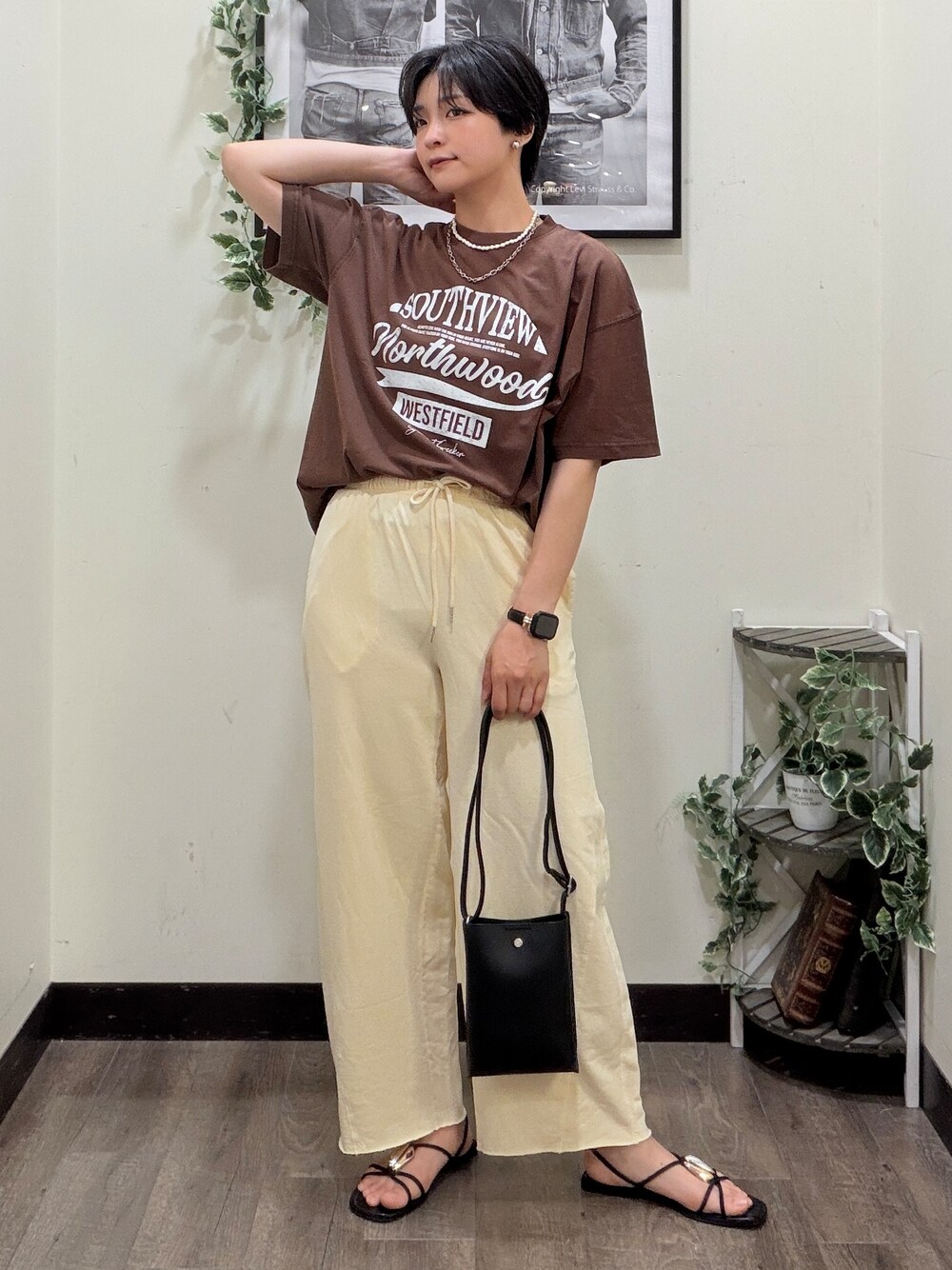 ブラウン系のTシャツ/カットソー、イエロー系のその他パンツ、ブラック系のショルダーバッグを着用したレディースの夏コーディネートの2枚目の写真