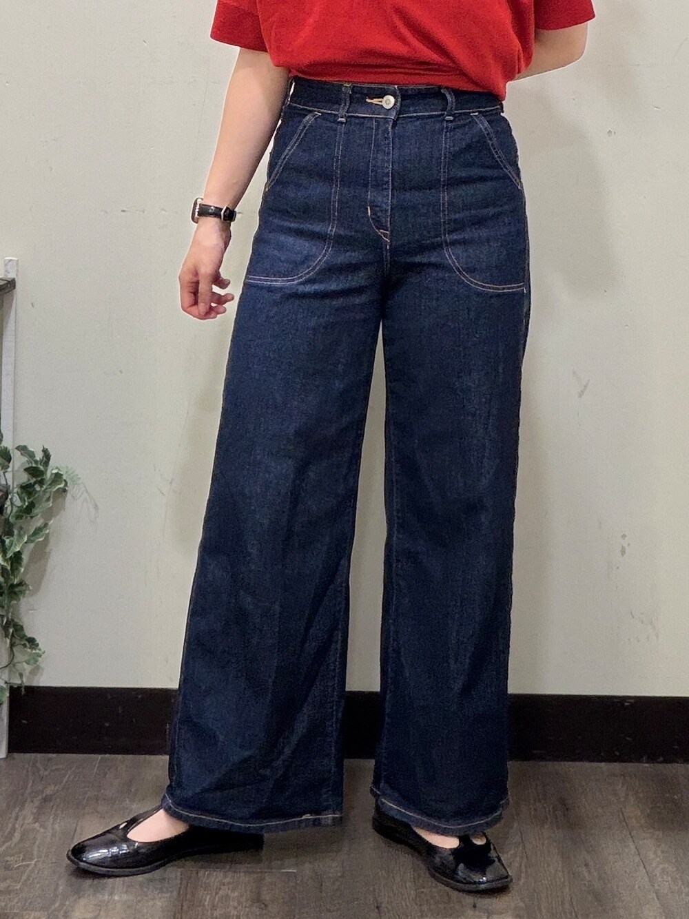 ブルー系のデニムパンツ、レッド系のニット/セーター、ホワイト系のスカートを着用したレディースの春コーディネートの6枚目の写真