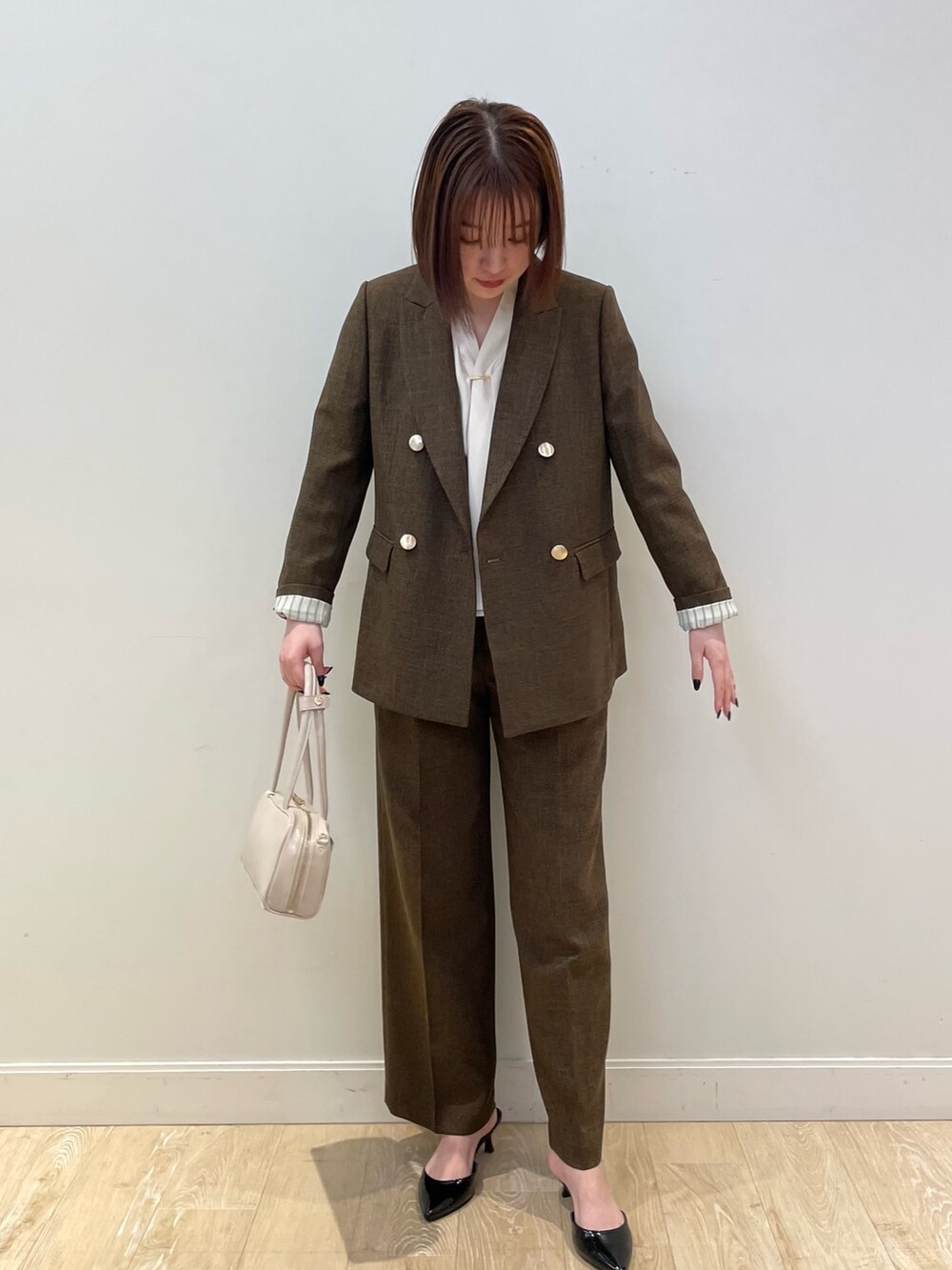 ブラウン系のテーラードジャケット、ブラウン系のその他パンツ、ホワイト系のシャツ/ブラウスを着用したレディースの夏コーディネートの6枚目の写真