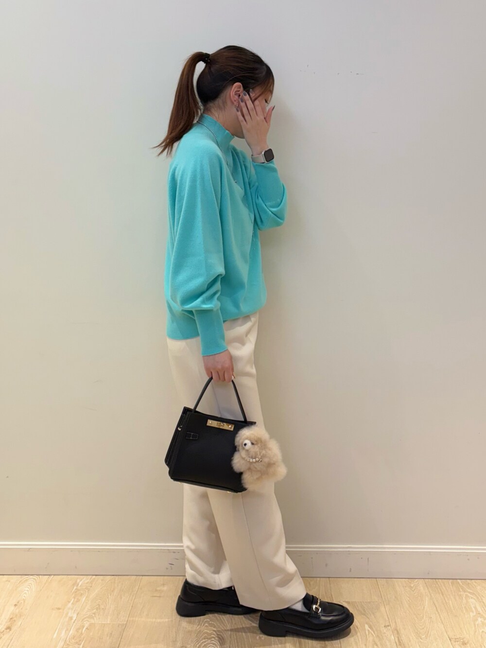 ブラック系のショルダーバッグ、ホワイト系のその他パンツ、グリーン系のニット/セーターを着用したレディースの秋コーディネートの2枚目の写真