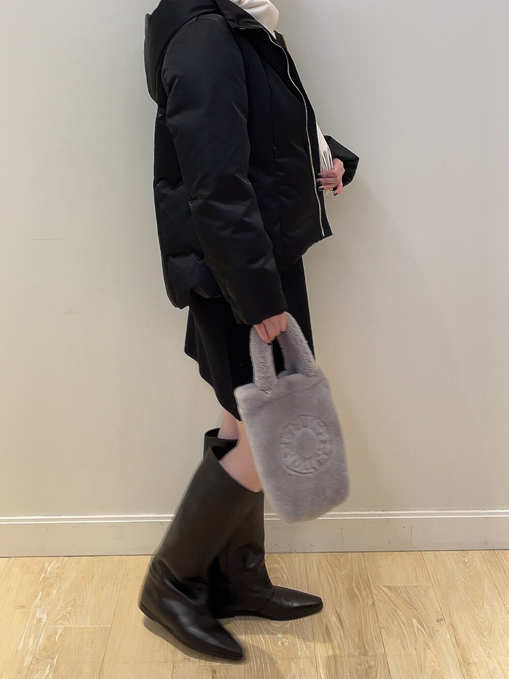 ホワイト系のニット/セーター、ブラック系のダウンジャケット/コート、ブラック系のスカートを着用したレディースの冬コーディネートの2枚目の写真