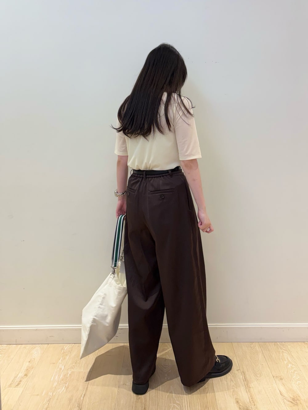 ホワイト系のエコバッグ/サブバッグ、ピンク系のTシャツ/カットソー、ブラウン系のその他パンツを着用したレディースの秋コーディネートの2枚目の写真
