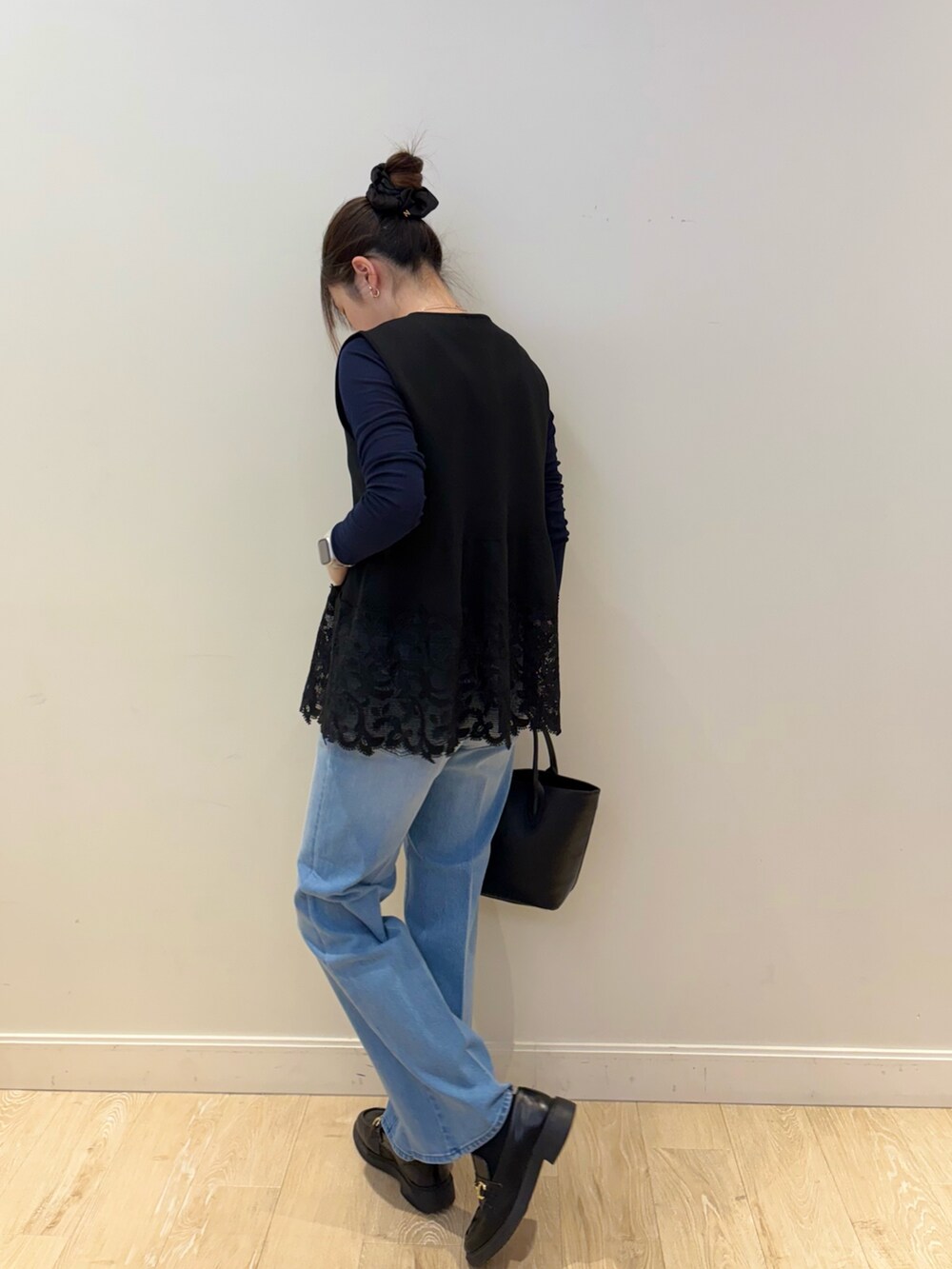 ブラック系のベスト、ブルー系のTシャツ/カットソー、ブラック系のトートバッグを着用したレディースの冬コーディネートの3枚目の写真