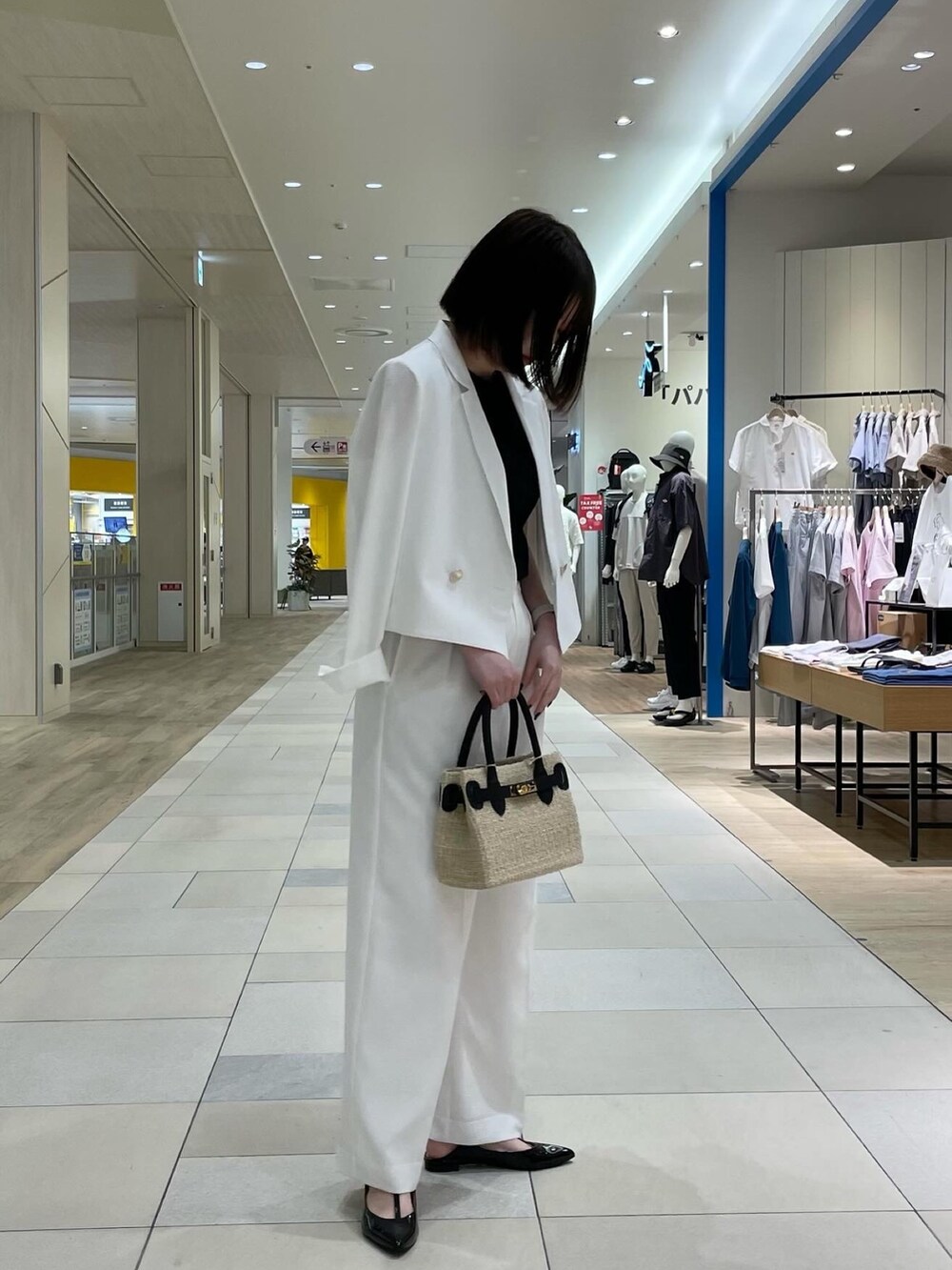 ホワイト系のその他パンツ、ブラック系のかごバッグ、ブラック系のパンプスを着用したレディースの夏コーディネートの3枚目の写真