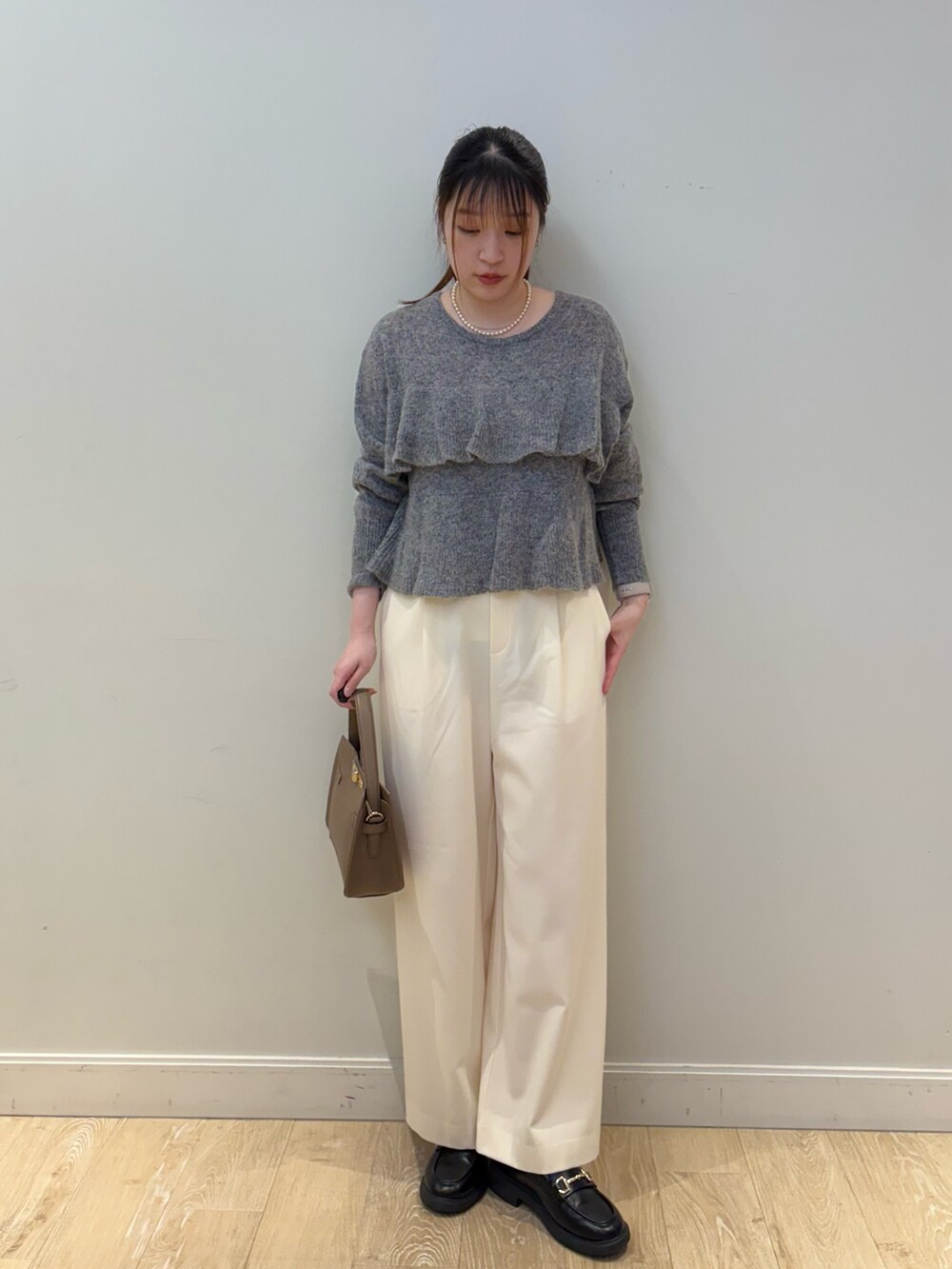 ベージュ系のショルダーバッグ、グレー系のニット/セーター、ホワイト系のその他パンツを着用したレディースの冬コーディネートの3枚目の写真
