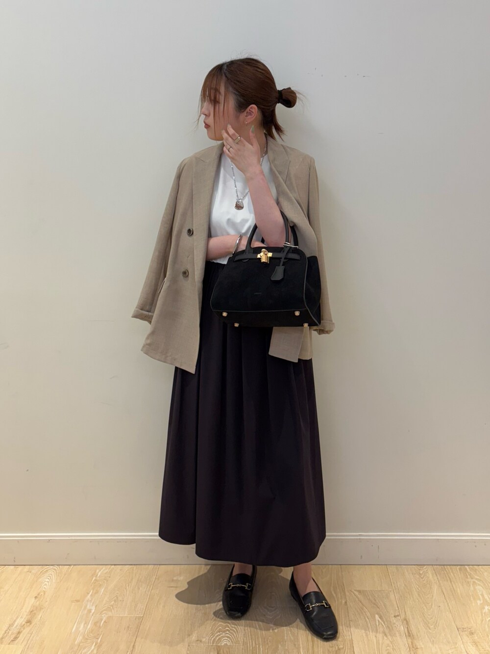 ブラック系のワンピース、ブラック系のトートバッグ、ベージュ系のテーラードジャケットを着用したレディースの夏コーディネートの3枚目の写真