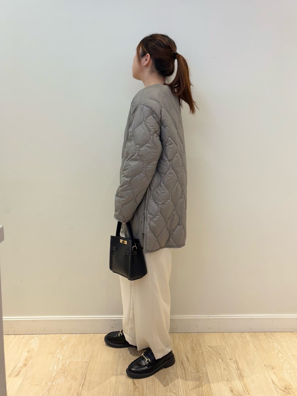 ブラック系のショルダーバッグ、ホワイト系のその他パンツ、ブルー系のニット/セーターを着用したレディースの秋コーディネートの3枚目の写真