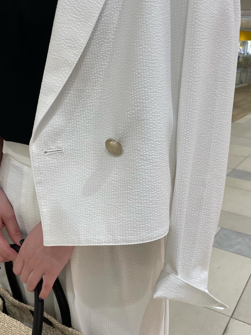 ホワイト系のその他パンツ、ブラック系のかごバッグ、ブラック系のパンプスを着用したレディースの夏コーディネートの4枚目の写真