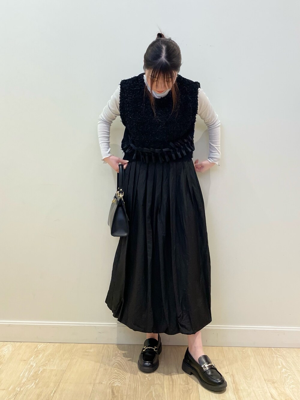 ブラック系のショルダーバッグ、シルバー系のTシャツ/カットソー、ブラック系のベストを着用したレディースの春コーディネートの2枚目の写真