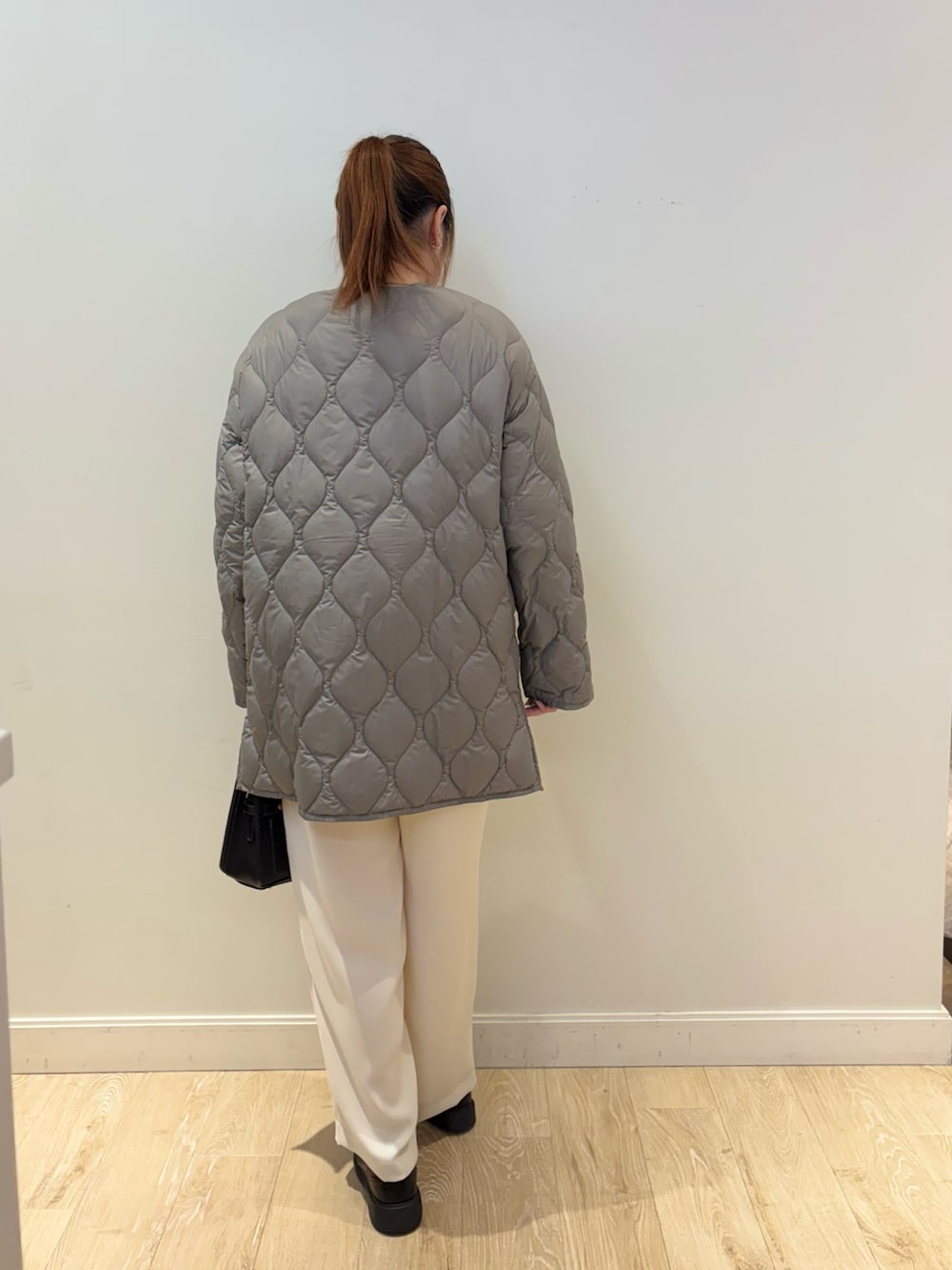 ブラック系のショルダーバッグ、ホワイト系のその他パンツ、ブルー系のニット/セーターを着用したレディースの秋コーディネートの2枚目の写真