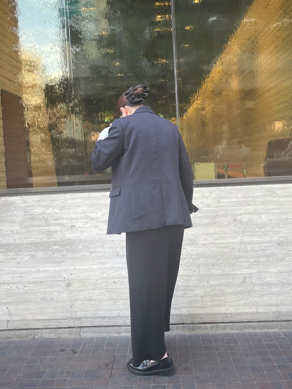 シルバー系のTシャツ/カットソー、ブラック系のスカート、ブルー系のテーラードジャケットを着用したレディースの冬コーディネートの4枚目の写真