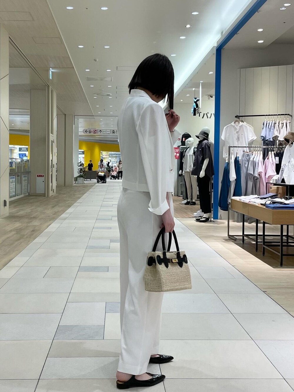 ホワイト系のその他パンツ、ブラック系のかごバッグ、ブラック系のパンプスを着用したレディースの夏コーディネートの2枚目の写真