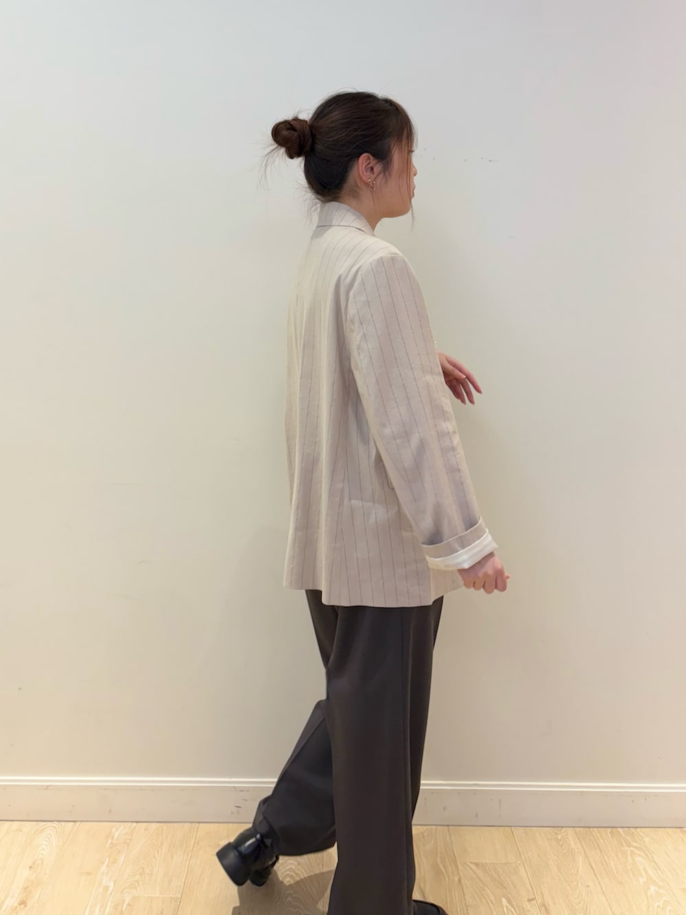 ベージュ系のテーラードジャケット、ホワイト系のタンクトップ、グレー系のその他パンツを着用したレディースの春コーディネートの2枚目の写真