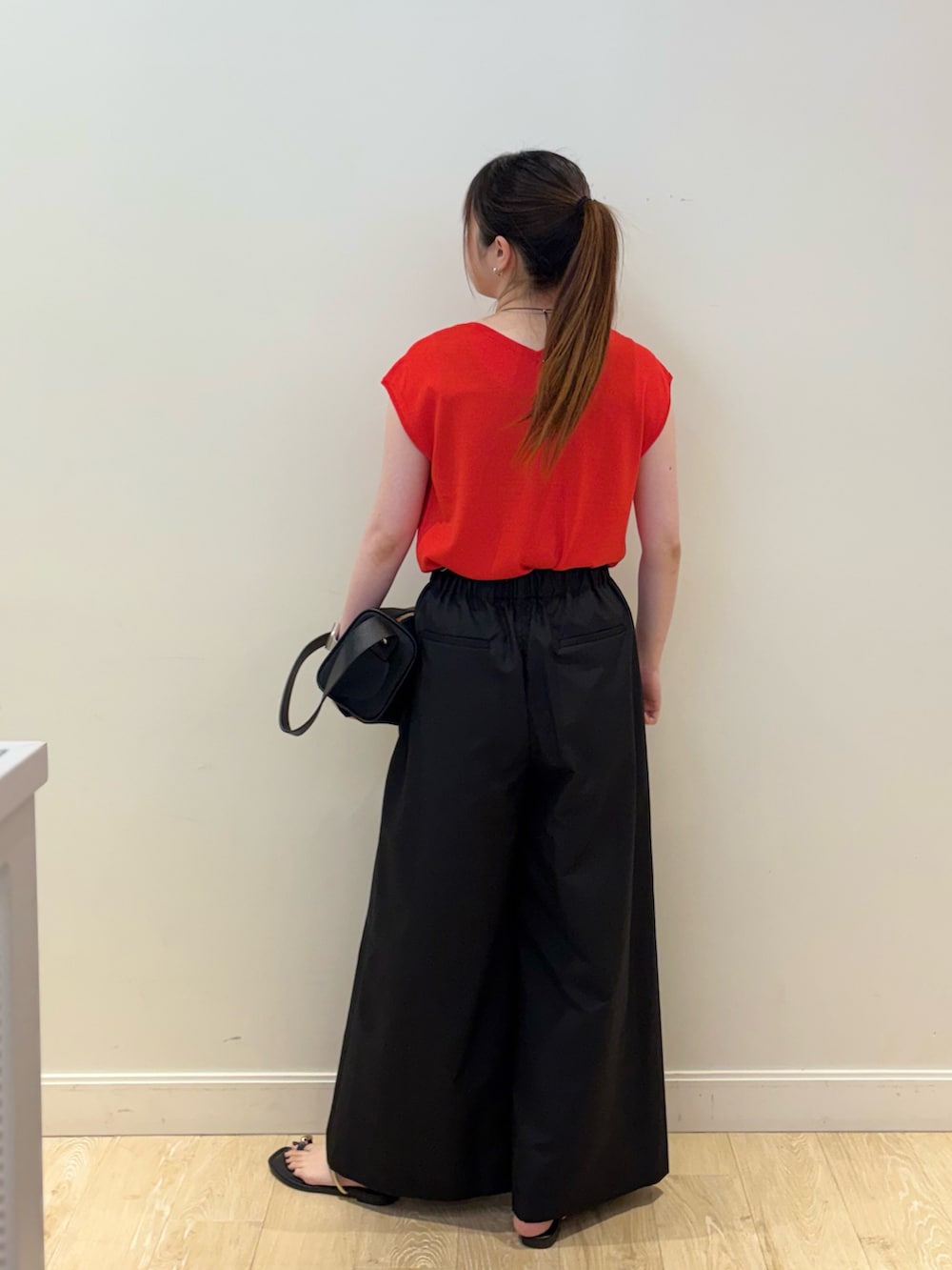 ブラック系のその他パンツ、ブラック系のショルダーバッグ、レッド系のニット/セーターを着用したレディースの夏コーディネートの3枚目の写真