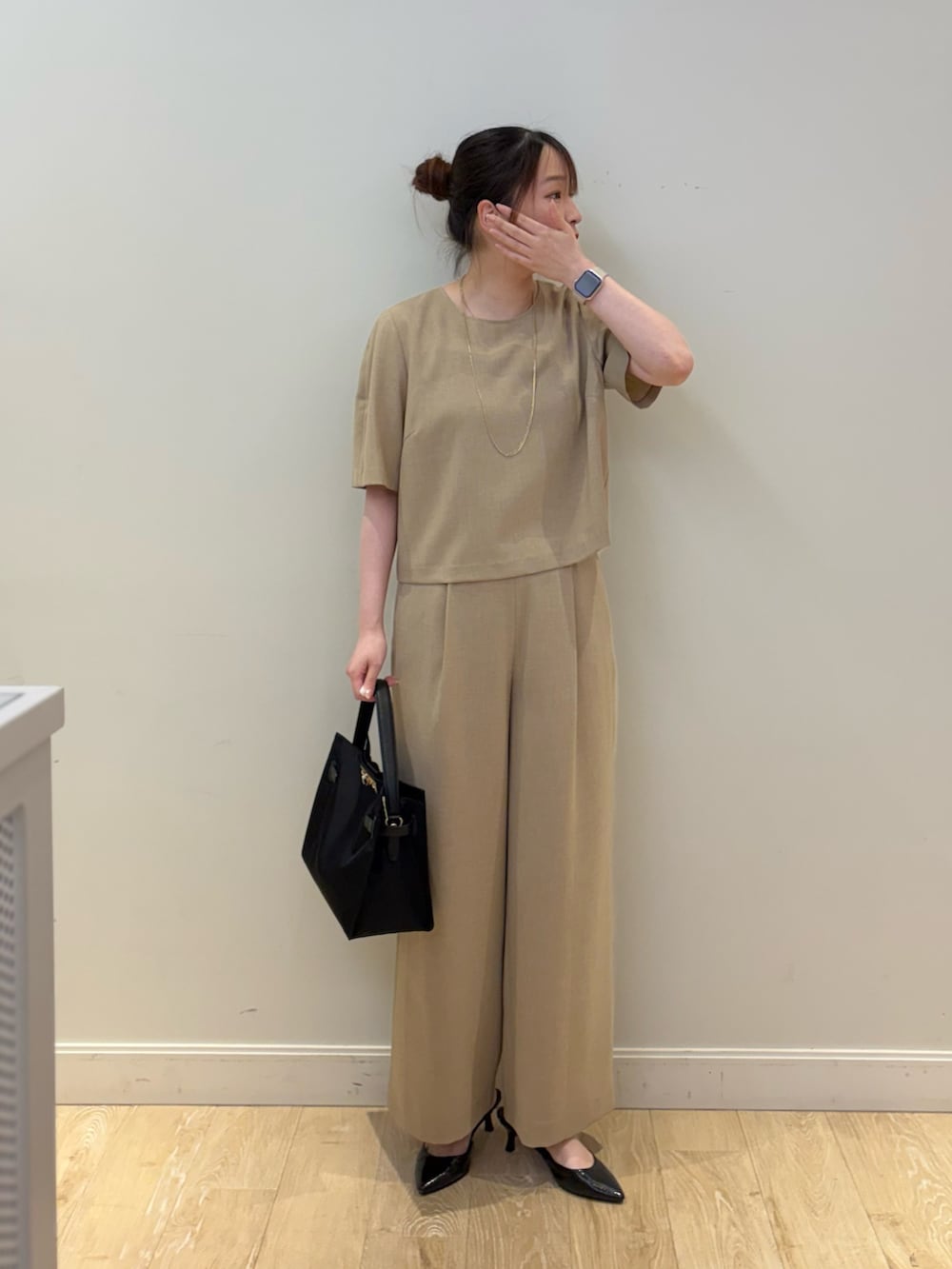ブラック系のトートバッグ、ベージュ系のシャツ/ブラウス、ベージュ系のその他パンツを着用したレディースの春コーディネートの4枚目の写真