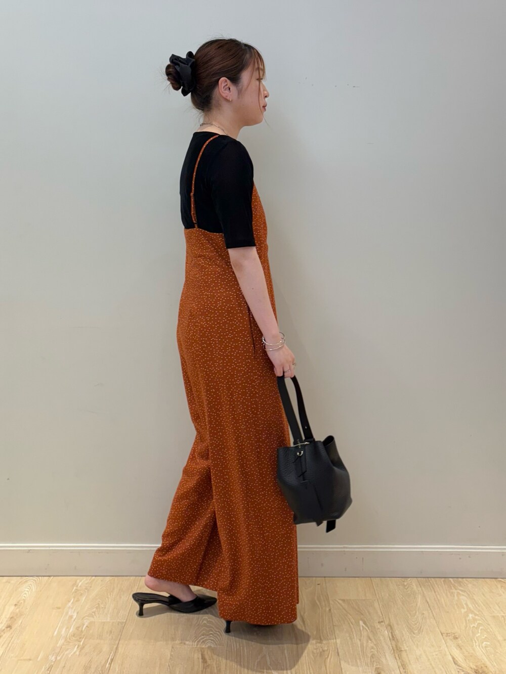 ブラック系のTシャツ/カットソー、ブラック系のショルダーバッグ、オレンジ系のつなぎ/オールインワンを着用したレディースの秋コーディネートの2枚目の写真