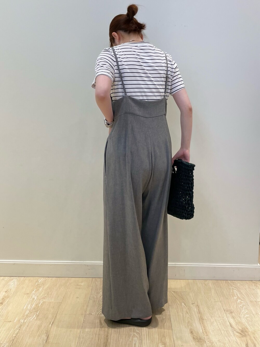 ベージュ系のかごバッグ、ホワイト系のTシャツ/カットソー、グレー系のつなぎ/オールインワンを着用したレディースの夏コーディネートの2枚目の写真