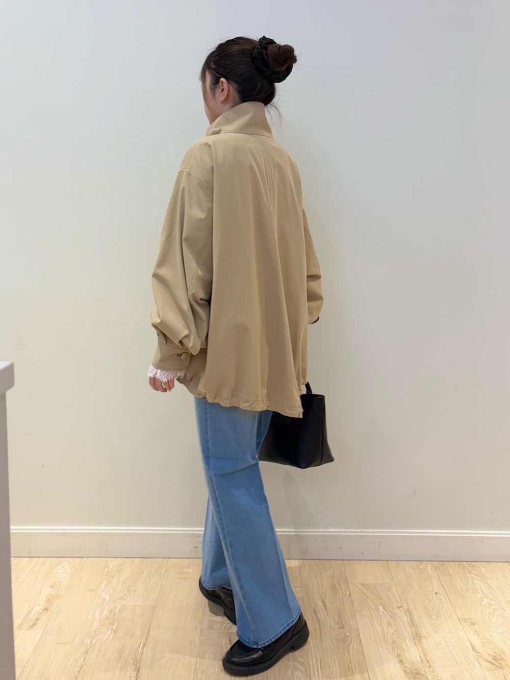 ブラック系のトートバッグ、ブルー系のデニムパンツ、ブルー系のニット/セーターを着用したレディースの冬コーディネートの3枚目の写真