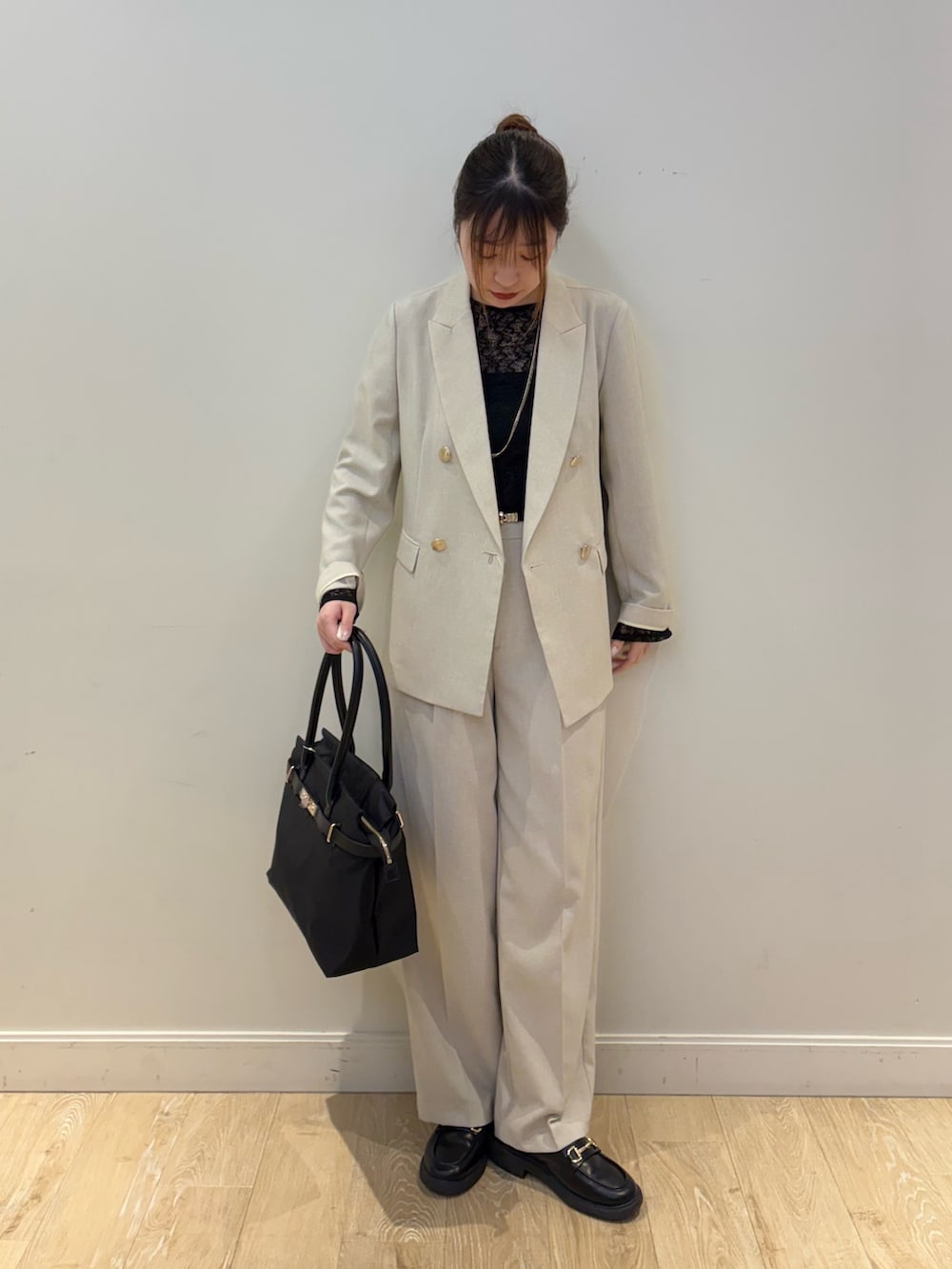 ブラック系のトートバッグ、ブラック系のTシャツ/カットソー、ベージュ系のテーラードジャケットを着用したレディースの春コーディネートの4枚目の写真