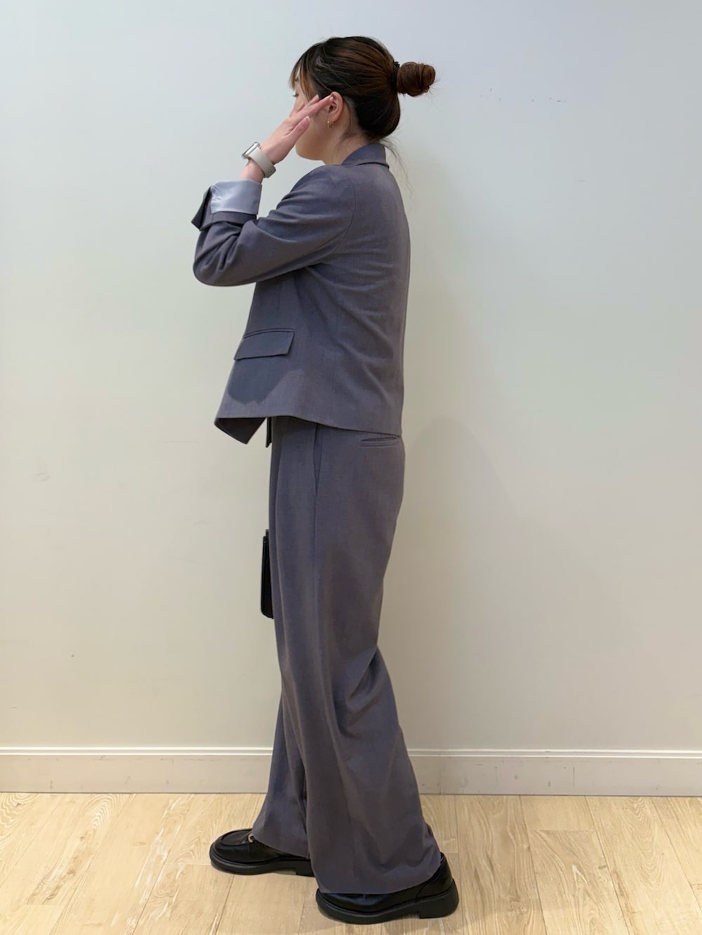 ブラック系のショルダーバッグ、ホワイト系のタンクトップ、グレー系のテーラードジャケットを着用したレディースの秋コーディネートの3枚目の写真