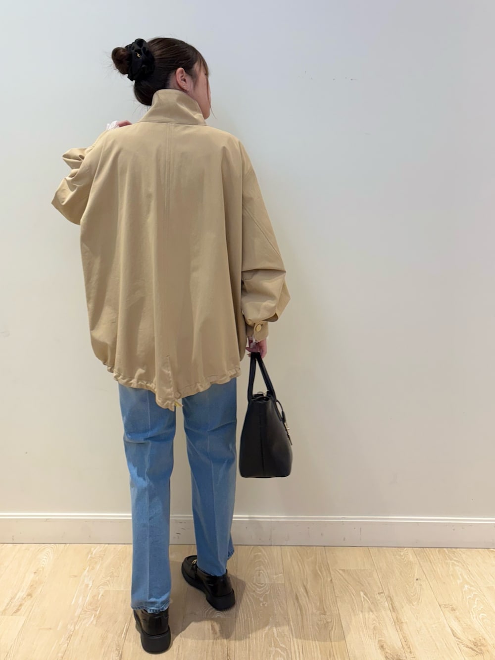 ブラック系のトートバッグ、ブルー系のデニムパンツ、ブルー系のニット/セーターを着用したレディースの冬コーディネートの2枚目の写真