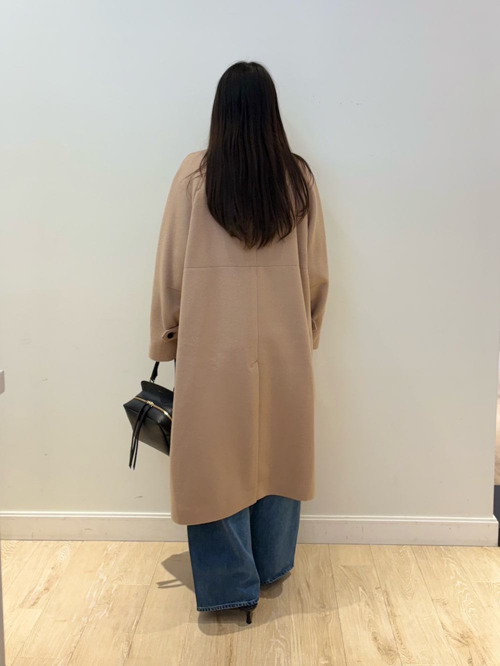 シルバー系のTシャツ/カットソー、ブルー系のデニムパンツ、ブラック系のショルダーバッグを着用したレディースの秋コーディネートの3枚目の写真