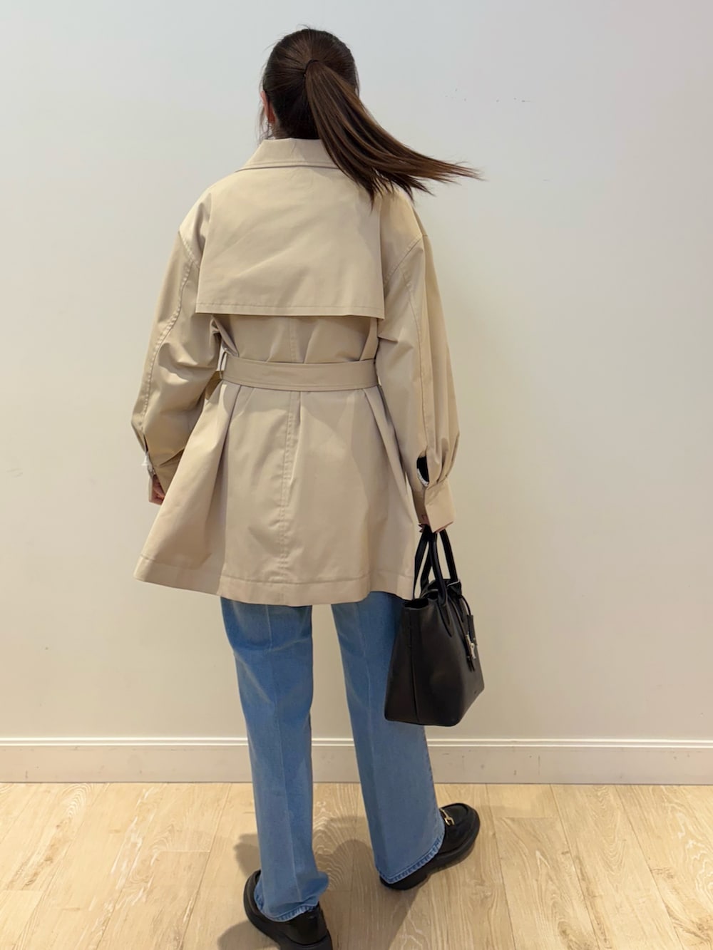 ブラック系のトートバッグ、ブルー系のデニムパンツ、ブルー系のニット/セーターを着用したレディースの冬コーディネートの5枚目の写真