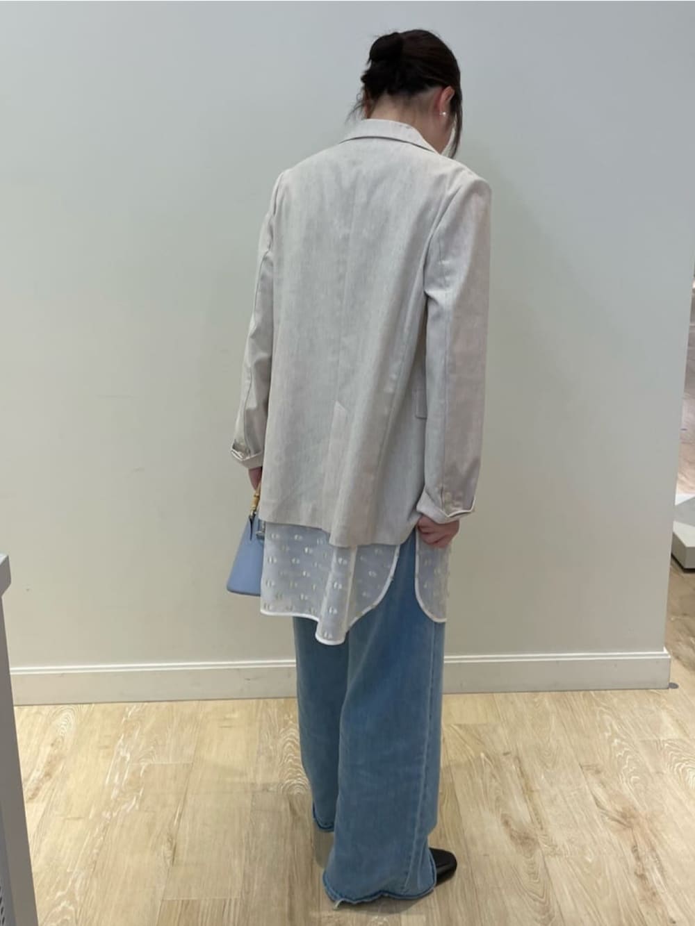 ベージュ系のテーラードジャケット、ホワイト系のシャツ/ブラウス、ホワイト系のキャミソールを着用したレディースの春コーディネートの4枚目の写真