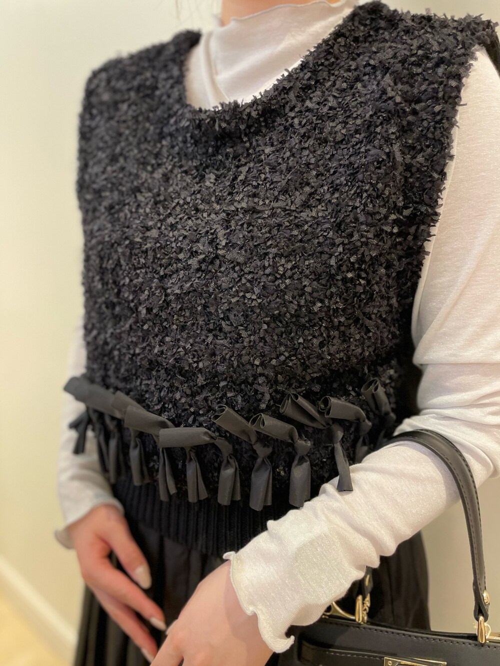 ブラック系のショルダーバッグ、シルバー系のTシャツ/カットソー、ブラック系のベストを着用したレディースの春コーディネートの6枚目の写真