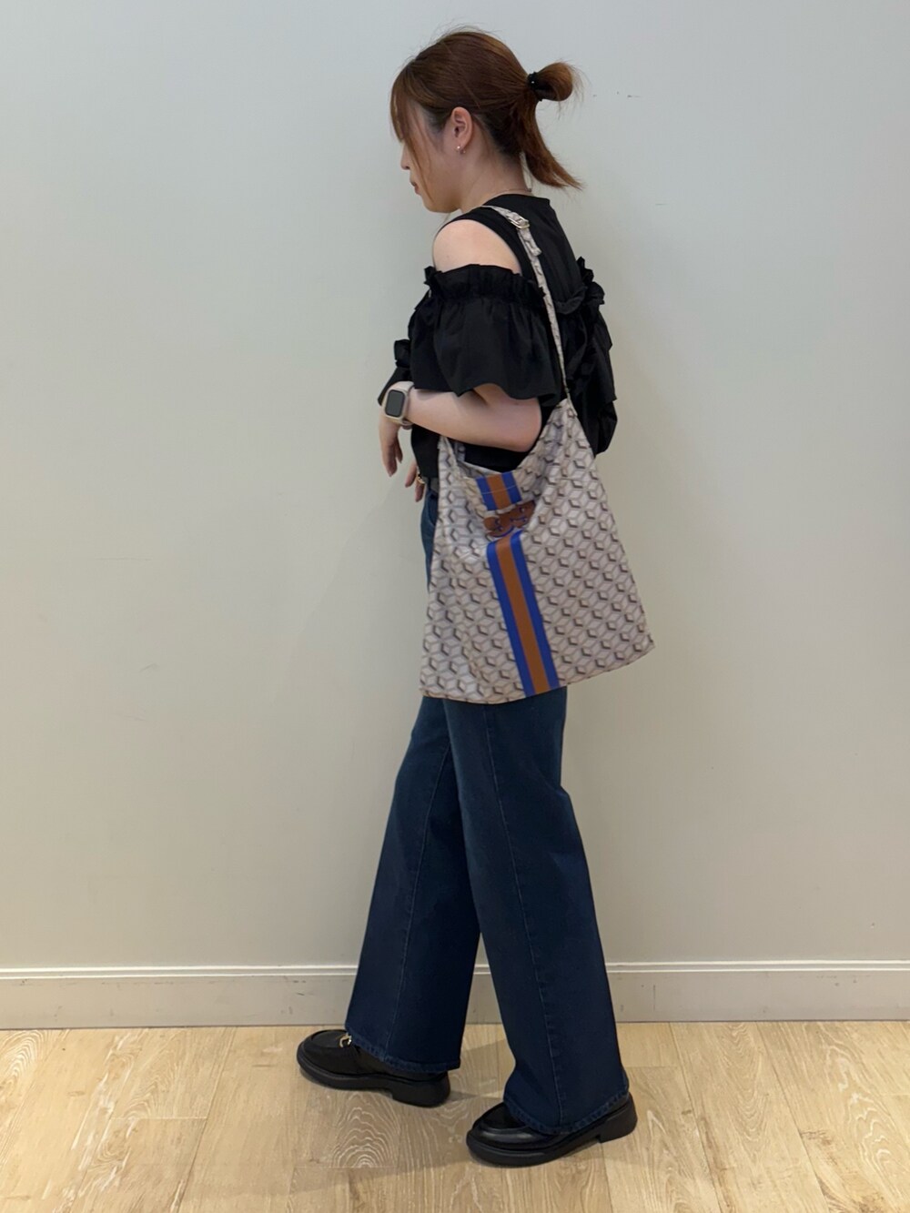 ブルー系のショルダーバッグ、ブルー系のデニムパンツ、ブラック系のベルトを着用したレディースの夏コーディネートの3枚目の写真