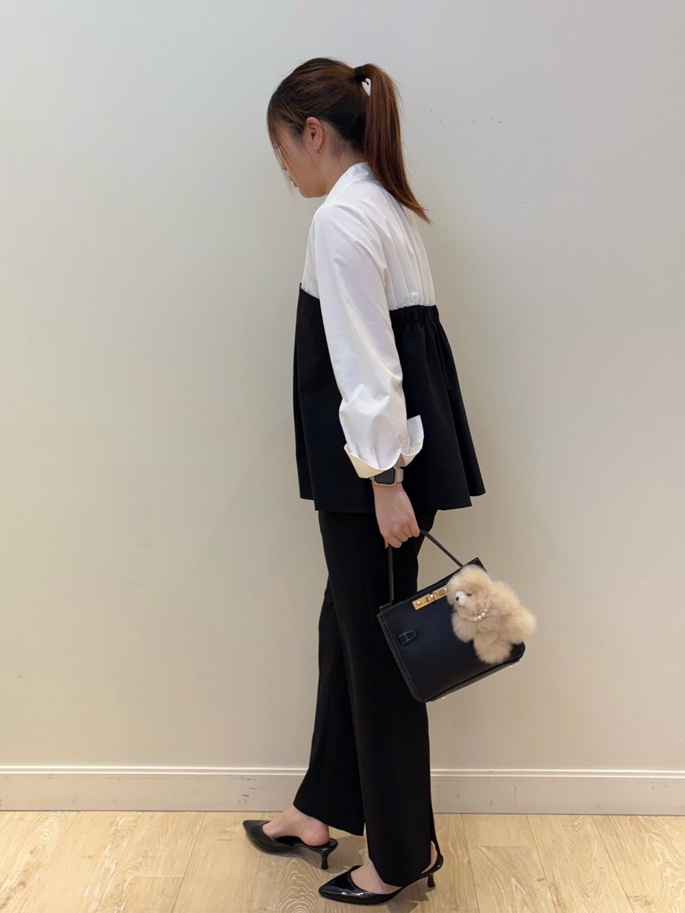ブラック系のショルダーバッグ、ホワイト系のシャツ/ブラウス、ブラック系のその他パンツを着用したレディースの秋コーディネートの3枚目の写真