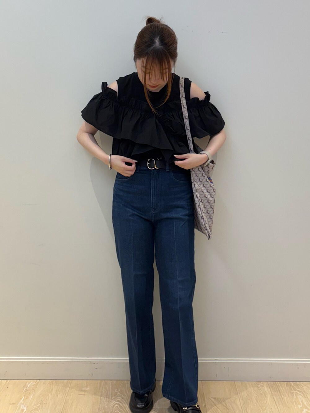 ブルー系のショルダーバッグ、ブルー系のデニムパンツ、ブラック系のベルトを着用したレディースの夏コーディネートの2枚目の写真